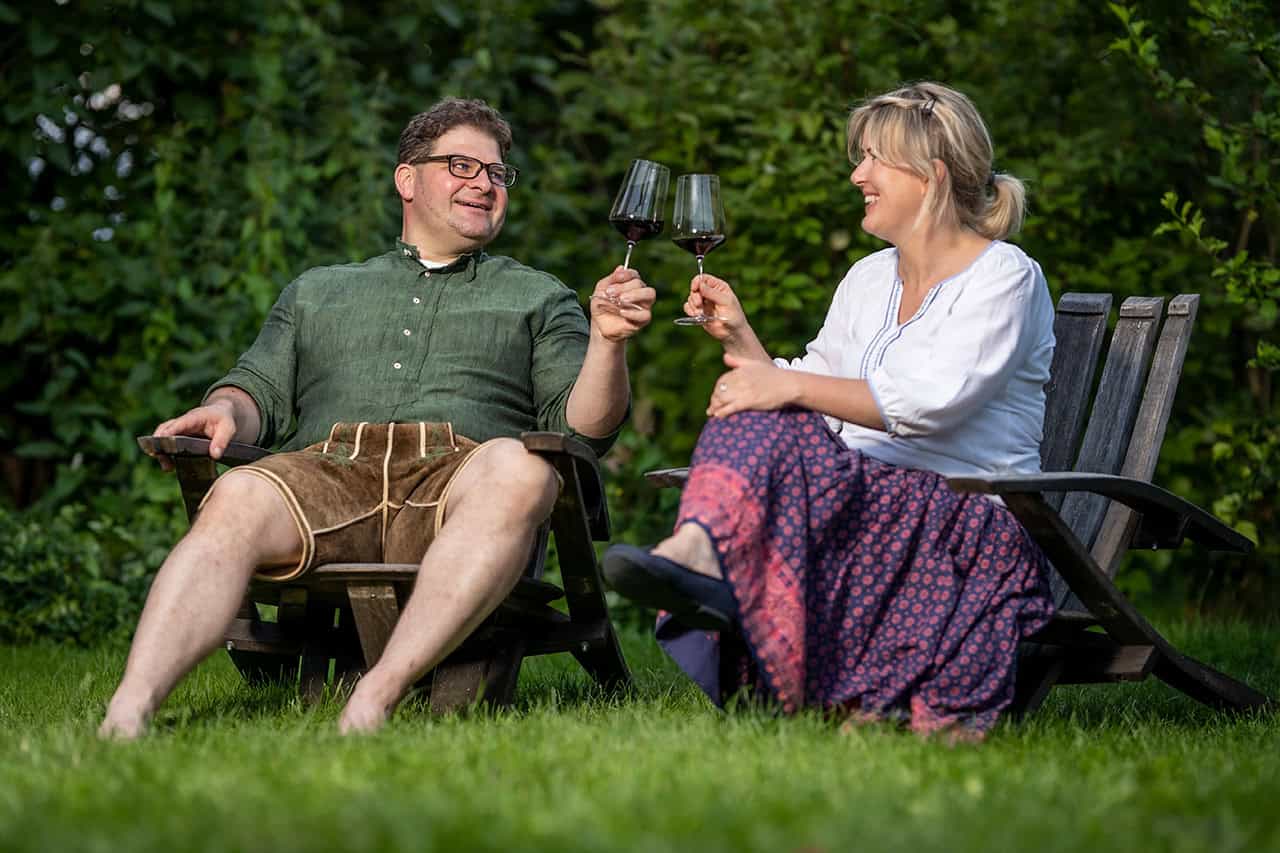 Ehepaar Stockinger sitzt im Garten und genießt ein Glas Wein